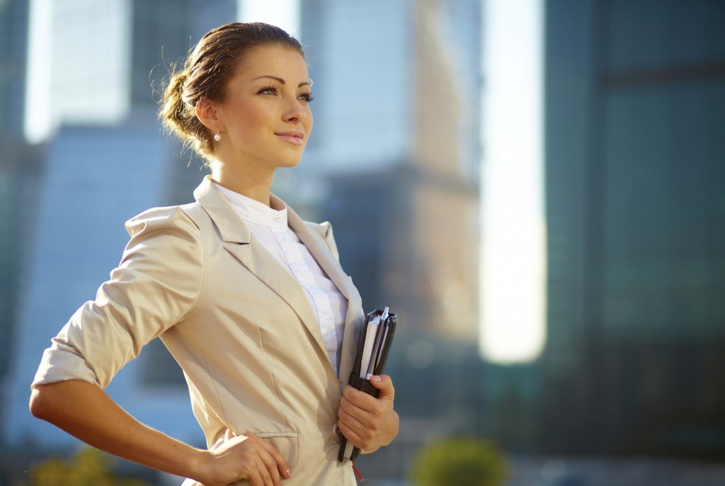 Portrait of cute young business woman outdoor over building background